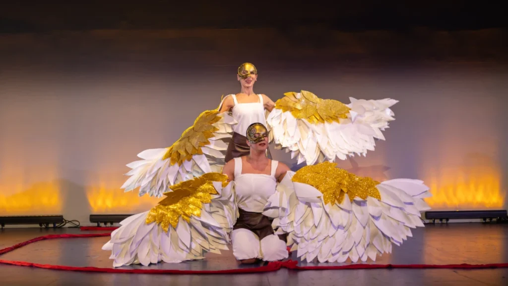 Daedalus and Icarus in flight with golden wings, dramatic dance theatre performance inspired by Greek mythology